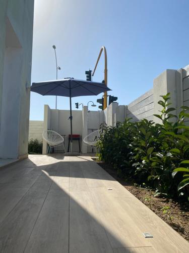 a patio with an umbrella and a table and chairs at Residenza Acqva di Mare in Cagliari