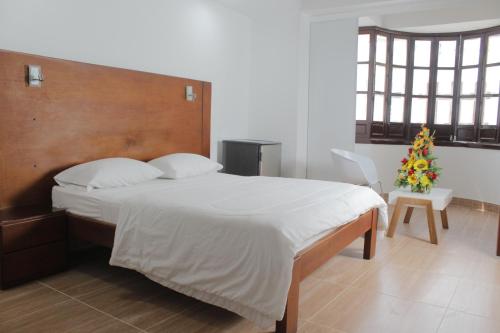 a bedroom with a large bed with a wooden headboard at Hotel Zaraya in Cúcuta