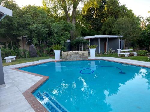 a swimming pool with blue water in a yard at Marion Lodge in Johannesburg
