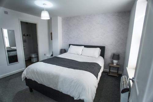 a bedroom with a large bed with white sheets and pillows at No 1 new inn apartments NEWLY RENOVATED in Newark upon Trent