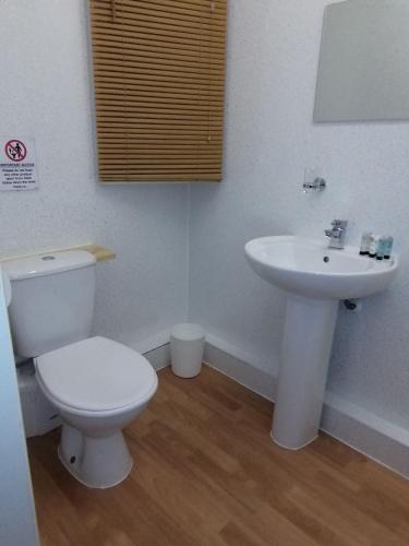 a bathroom with a toilet and a sink at The Parkers Arms - The home of Cattlemans Steakhouse in Paignton