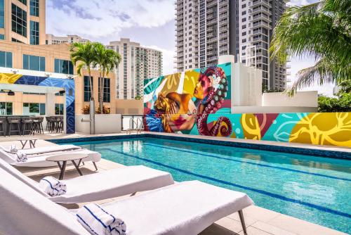 a swimming pool with chaise lounge chairs and a mural at Hyatt Centric Las Olas Fort Lauderdale in Fort Lauderdale