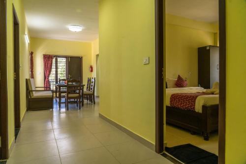 a room with a bedroom with a bed and a table at VGR-HOMESTAY in Kodaikānāl