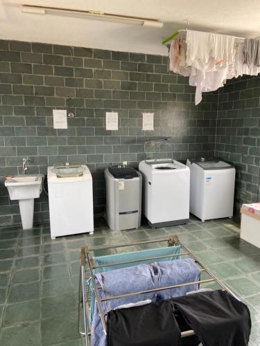 a bathroom with four washing machines and a sink at Lindo apartamento em Caxambu in Caxambu