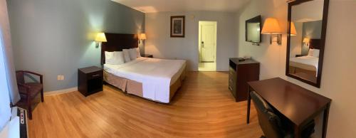 Habitación de hotel con cama y espejo en Crystal Inn Eatontown, en Eatontown