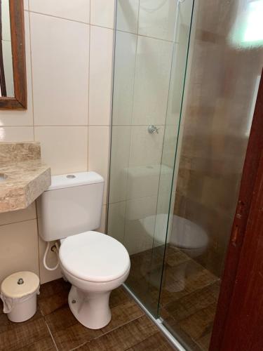 a bathroom with a toilet and a glass shower at Casa de Temporada em Capitólio (Charme e Aconchego) in Capitólio