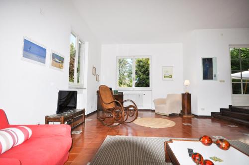 a living room with a red couch and a tv at Villa il Forte in Forte dei Marmi