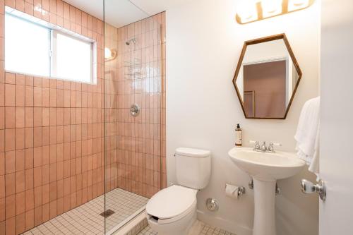 a bathroom with a toilet and a sink and a mirror at Selina Gold Dust in Miami