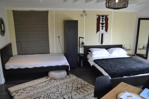 a bedroom with two beds and a table and a rug at Greenfield Lodge in Brighton & Hove