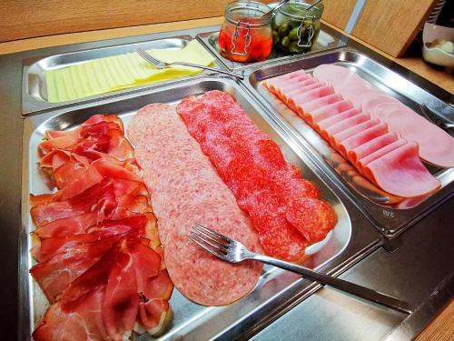 a tray of meats and vegetables on a stove at Motel Hohenems in Hohenems