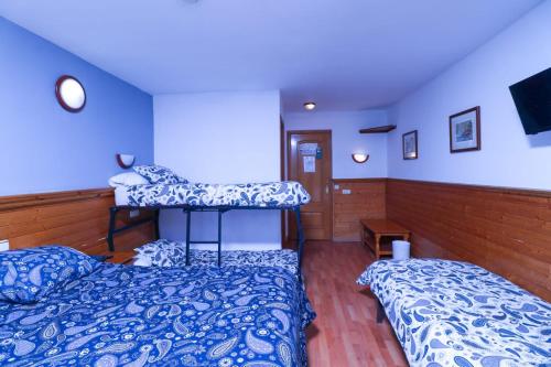 
a bedroom with two beds and a desk at Hotel Merino in Pas de la Casa

