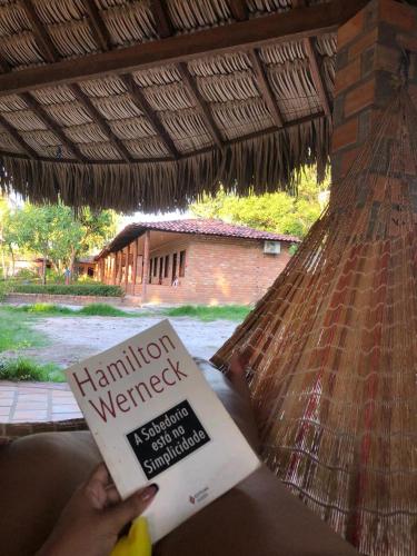 a person reading a book in a hammock at Pousada do Riacho in Barreirinhas