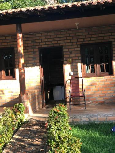 a chair sitting outside of a brick house at Pousada do Riacho in Barreirinhas
