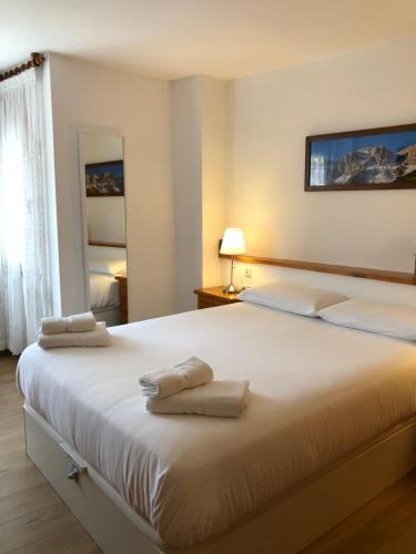 a bedroom with a large white bed with towels on it at Mariajo’s House in Puigcerdà