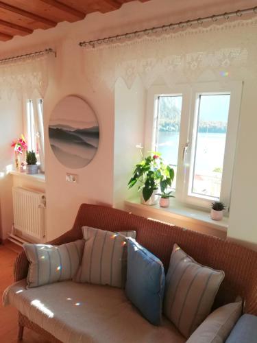 a living room with a couch and two windows at Apartment Müllerstiege in Hallstatt