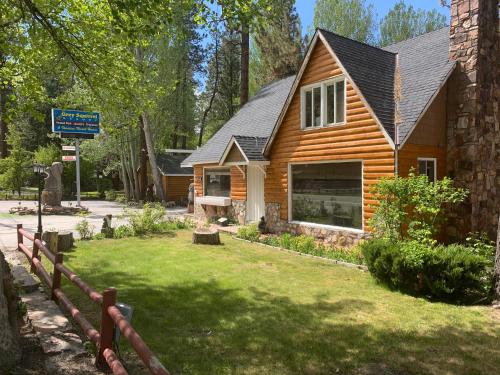 uma casa de madeira com uma cerca em frente em Grey Squirrel Resort em Big Bear Lake