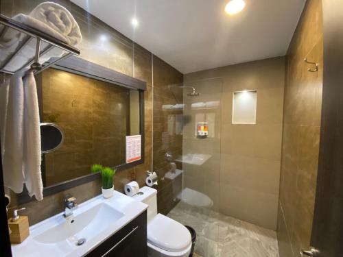 ein Bad mit einem Waschbecken, einem WC und einer Dusche in der Unterkunft Galapagos Sunset Hotel in Puerto Baquerizo Moreno