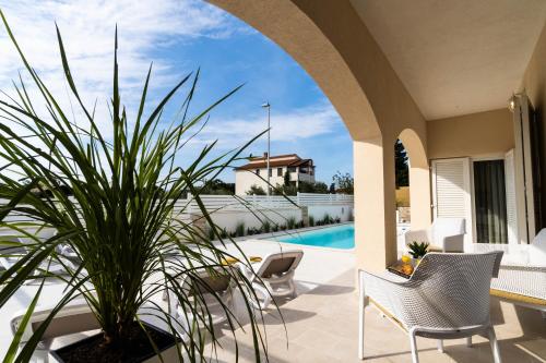 a patio with a table and chairs and a plant at Villa Ostone in Pula