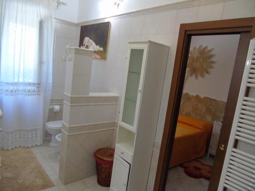 a bathroom with a toilet and a sink and a mirror at Villa Tonia in Fasano