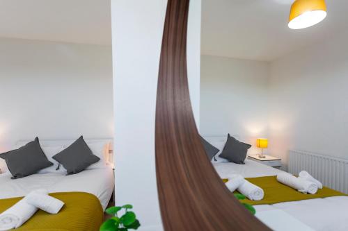 a bedroom with two beds and a mirror at Jasmine Villa A - Ideal for QMC & Uni - Free parking in Nottingham