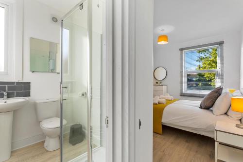 Jasmine Villa A - Ideal for QMC & Uni - Free parking في نوتينغهام: حمام مع دش وغرفة نوم مع سرير