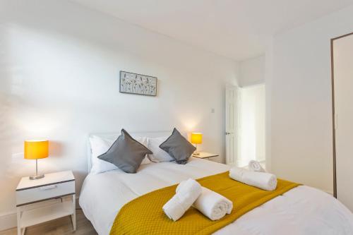 sypialnia z dużym białym łóżkiem z ręcznikami w obiekcie Jasmine Villa A - Ideal for QMC & Uni - Free parking w Nottingham