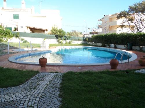 ein großer Pool in der Mitte eines Gartens in der Unterkunft Hotel Monaco in Faro