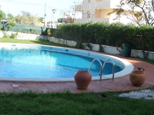 a small swimming pool with two vases next to it at Hotel Monaco in Faro