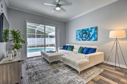 a living room with a white couch and blue pillows at Apopka Single-Story Home with Private Lanai and Pool! in Orlando
