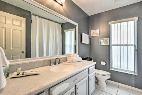 a bathroom with a sink and a toilet and a mirror at Apopka Single-Story Home with Private Lanai and Pool! in Orlando