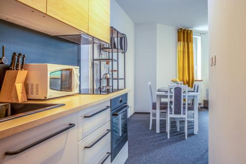 una cucina con forno a microonde e tavolo con sedie di Apartman Amore a Bešeňová