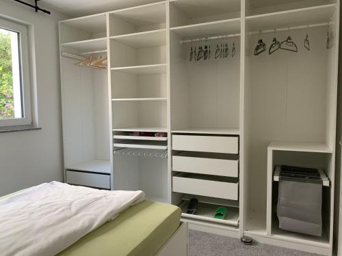 1 dormitorio con cama y armario blanco en Firmen & Ferienwohnung Brecht 1, en Waibstadt