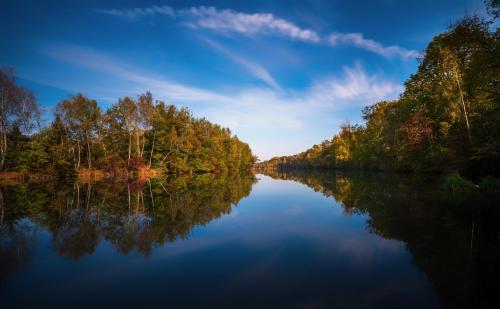 a river with trees reflecting in the water at Motel Hohenems in Hohenems