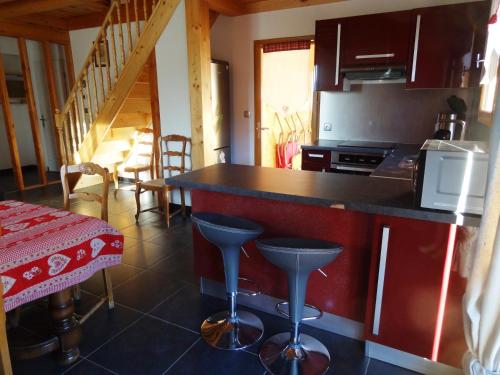 a kitchen with a counter and stools in a room at Gite de Champ Chaulier in Crots