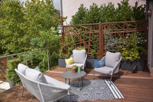 a patio with chairs and a table on a deck at Chambre d'hôtes Le Cadran des Chauvelles in Nevers