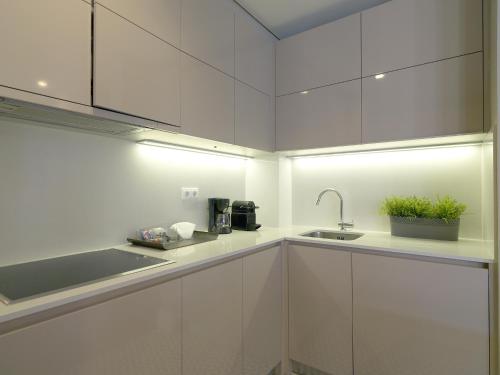 a kitchen with white cabinets and a sink at FLH New Oporto Apartments - São Bento in Porto