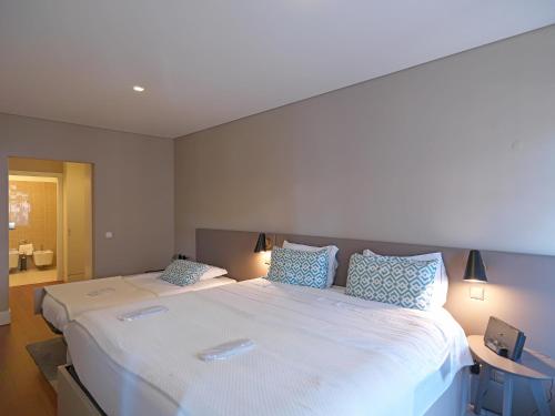 a bedroom with a large bed with two pillows at FLH New Oporto Apartments - São Bento in Porto