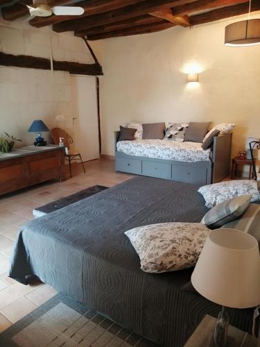 - une grande chambre avec 2 lits et une table dans l'établissement Le clos des augers, chambres d'hôtes et roulotte, à Azay-sur-Cher