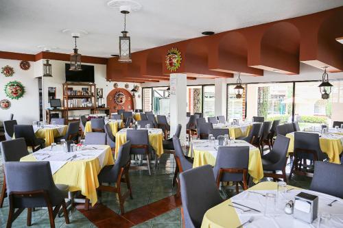 a restaurant with tables and chairs with yellow table cloths at Hotel & Suites Villa del Sol in Morelia