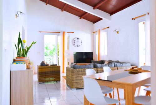 a living room with a table and a couch at Villa Sunrise in Deshaies