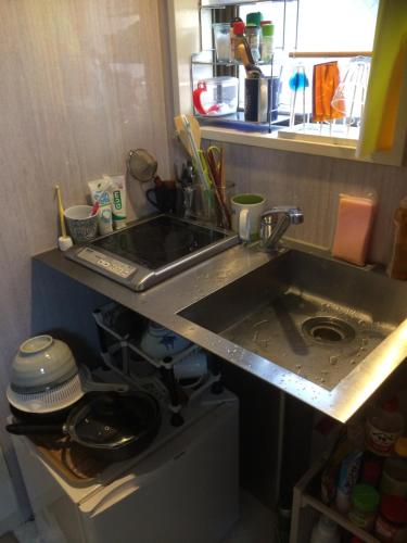 a kitchen with a sink and a counter top at Shinjuku Hostel in Tokyo
