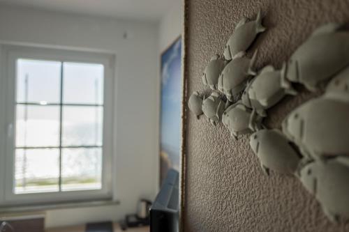 a bunch of cups hanging on a wall at AKZENT Strandhotels Seestern, Delphin & Lachs in Wilhelmshaven