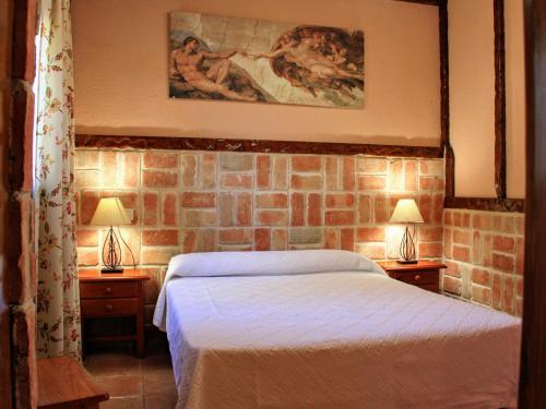 a bedroom with a bed and two lamps on tables at Complejo Turístico Las Cañadas Casas de Campo- Actividades Gratuitas Todos los Fines de Semana in Baños de Montemayor