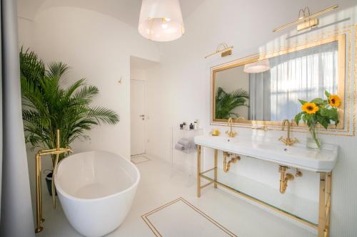 y baño con bañera, lavabo y espejo. en Luxury Suite with Terrace en Sant'Agnello