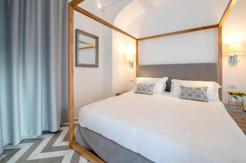 1 dormitorio con 1 cama blanca con marco de madera en Luxury Suite with Terrace en Sant'Agnello