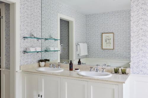 a bathroom with two sinks and a mirror at The Mayflower Inn & Spa, Auberge Collection in Washington