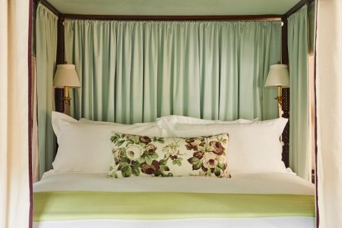 a bed with a green headboard and pillows at The Mayflower Inn & Spa, Auberge Collection in Washington