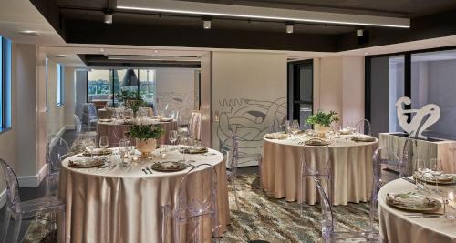 a room with two tables with silver tablecloths and chairs at Hotel Zena Washington DC in Washington