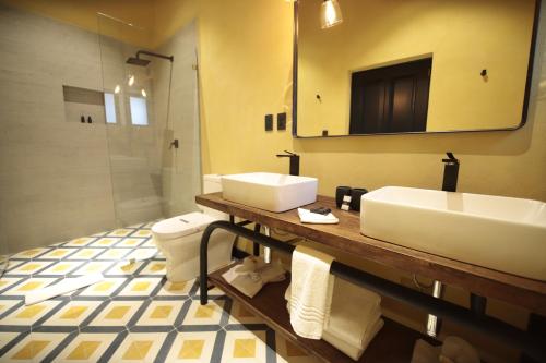 a bathroom with a sink and a toilet and a mirror at Antigua Trece Hotel Fusión in Guanajuato