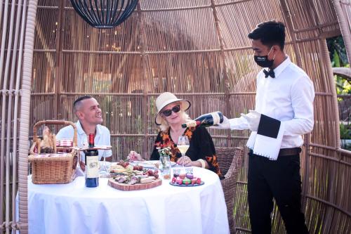 a man and a woman sitting at a table with food at Keliki Luxury Lodge in Ubud